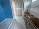 Bathroom with blue tile shower and gray cabinets. Ready to be customized! at 315 Chesapeake Commons St # 102, Garner, NC 27529