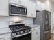 Close-up of a modern kitchen with stainless steel appliances, granite countertops, and stylish cabinetry at 318 Church St # 39, Wendell, NC 27591