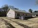 Back exterior of home under construction with a gray shingled roof, windows, in a large backyard setting at 327 S Main St, Four Oaks, NC 27524
