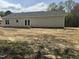 The back of the one-story home features gray siding, a patio area and a large backyard, offering ample space at 327 S Main St, Four Oaks, NC 27524
