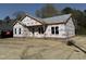 Front exterior of a home under construction with gray shingled roof and brick foundation in a serene setting at 327 S Main St, Four Oaks, NC 27524