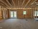 Open-concept living room with framing, featuring natural light from windows and patio door at 327 S Main St, Four Oaks, NC 27524