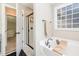 Bathroom features a soaking tub, patterned window, and shower with glass door at 329 Silver Creek Dr, Clayton, NC 27520