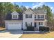 Two-story home with gray siding, black shutters, and a two-car garage at 329 Silver Creek Dr, Clayton, NC 27520