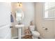 Cozy powder room featuring a pedestal sink, oval mirror, and modern fixtures at 329 Silver Creek Dr, Clayton, NC 27520