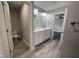 Modern bathroom featuring a double sink vanity, modern lighting, with an adjacent toilet area and carpeted bedroom at 333 S Main St, Four Oaks, NC 27524
