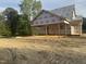 New construction of a home showcasing its framing, brick foundation, and Grip Rite weather barrier at 333 S Main St, Four Oaks, NC 27524