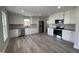 Modern kitchen features stainless steel appliances, white cabinets, granite countertops, and wood flooring at 333 S Main St, Four Oaks, NC 27524