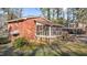 A brick house with a screened-in porch and a covered parking area surrounded by lush greenery at 3416 Oates Dr, Raleigh, NC 27604