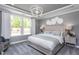 Serene bedroom with tray ceilings, large window, neutral tones, and modern lighting fixture at 344 Arcadius Dr, Clayton, NC 27520