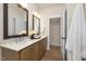 Modern bathroom with wood cabinets, double mirrors, quartz countertops, and wood-look floors at 344 Church St, Morrisville, NC 27560