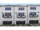 Rear view of the townhome featuring private balconies, garage and well-manicured green space at 344 Church St, Morrisville, NC 27560