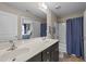 Modern bathroom with double sinks, shower-tub combo, and stylish fixtures. Bedroom visible in mirror at 372 Lynshire Ave, Clayton, NC 27527