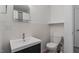 Clean white bathroom featuring a single sink vanity, white tile, and modern fixtures at 3936 Lake Ferry Dr, Raleigh, NC 27606