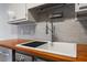 Close-up of a modern farmhouse-style sink with sleek fixtures and wood countertop at 3936 Lake Ferry Dr, Raleigh, NC 27606