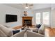 Staged living room with a fireplace, hardwood floors, and neutral-toned seating arrangement at 3936 Lake Ferry Dr, Raleigh, NC 27606