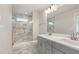 Bathroom with a double sink vanity, large mirror, marbled tile flooring, and a glass-enclosed shower at 509 Sherron Rd # 22, Durham, NC 27703