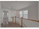 Bright hallway with wood floors, white walls, a wood and white railing, and natural light from the windows at 509 Sherron Rd # 22, Durham, NC 27703