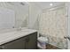 Bathroom with patterned shower curtain, vanity, and large mirror at 6012 Kayton St, Raleigh, NC 27616