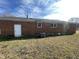 Image of a house's backyard with visible brick wall, white trim, and a manicured lawn at 602 S Massey St, Selma, NC 27576