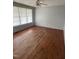 Bright living room featuring hardwood floors, large windows, and a ceiling fan at 602 S Massey St, Selma, NC 27576