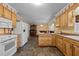 Open kitchen with wood cabinetry, updated appliances, and view to the dining area at 6480 Union Ridge Rd, Burlington, NC 27217