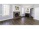 Open-concept living room featuring a brick fireplace, wood floors, and view to the sink at 849 Jeffreys Rd, Rocky Mount, NC 27804