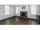 Open-concept living room featuring a brick fireplace, wood floors, and large windows at 849 Jeffreys Rd, Rocky Mount, NC 27804