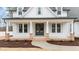 Inviting front porch featuring brick accents, white columns, and a stylish double-door entrance at 120 Lane Farms Way Way, Holly Springs, NC 27540