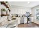 Well-lit kitchen featuring stainless steel appliances, wood floors, granite countertops, and white cabinetry at 1620 Oakland Hills Way, Raleigh, NC 27604