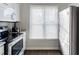 Modern kitchen showcasing stainless steel refrigerator, granite countertops, wood floors, and natural light at 1620 Oakland Hills Way, Raleigh, NC 27604