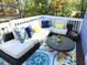 Outdoor patio with sectional seating, colorful rug, and table with wine and glasses at 1620 Oakland Hills Way, Raleigh, NC 27604