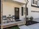 Close up of the front porch with seating, a black front door, and well-kept landscaping at 2218 Christian Light Rd, Fuquay Varina, NC 27526