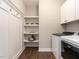 Functional laundry room with washer, dryer, shelving, and convenient storage hooks at 2218 Christian Light Rd, Fuquay Varina, NC 27526