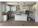 Bright kitchen with white cabinets, large island, stainless appliances, and designer light fixtures at 253 Tidal Pool Way, Cary, NC 27519