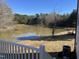 Picturesque backyard features a serene pond surrounded by trees, creating a peaceful and private retreat at 3204 Overlook Ct, Burlington, NC 27215