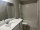 Bright bathroom featuring a shower-tub combo with white subway tile, a white vanity, and a large mirror at 3204 Overlook Ct, Burlington, NC 27215