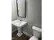 Elegant bathroom with a pedestal sink and a modern toilet, combining classic style with modern convenience at 3204 Overlook Ct, Burlington, NC 27215
