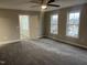 Bedroom featuring neutral walls and carpet with a ceiling fan and windows leading to another room at 3204 Overlook Ct, Burlington, NC 27215