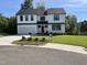 Beautifully landscaped two-story home with black trimmed windows, a white exterior, and a lovely green lawn at 3204 Overlook Ct, Burlington, NC 27215