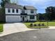 Eye-catching two-story house showcasing a lush green lawn, contemporary black-and-white color palette, and mature trees at 3204 Overlook Ct, Burlington, NC 27215