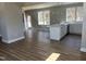 Open kitchen concept with an island, hardwood flooring, white cabinetry, and stylish lighting, ready for entertaining at 3204 Overlook Ct, Burlington, NC 27215