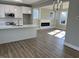 Open kitchen and living room space featuring hardwood floors, a kitchen island, and a cozy fireplace feature at 3204 Overlook Ct, Burlington, NC 27215