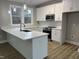 Modern kitchen showcasing white cabinets, a center island, granite countertops, and stainless steel appliances at 3204 Overlook Ct, Burlington, NC 27215