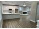 Stylish kitchen with white cabinets, an island with white countertops, stainless steel appliances, and hardwood flooring at 3204 Overlook Ct, Burlington, NC 27215