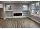 Modern living room featuring an electric fireplace, hardwood flooring, custom built-ins, and lots of natural light at 3204 Overlook Ct, Burlington, NC 27215