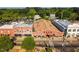 Aerial view of commercial buildings with retail shops on street with trees and parked cars at 3287 Roundly Rd # 13, New Hill, NC 27562