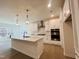 Bright, modern kitchen with stainless steel appliances, pendant lighting, and a large kitchen island at 3287 Roundly Rd # 13, New Hill, NC 27562