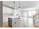 Modern kitchen with white cabinetry, stainless steel appliances, and a central island overlooking the living area at 343 Church St # 66, Wendell, NC 27591