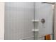 A frameless glass shower enclosure with gray vertical tiles and built-in shelves at 347 Church St # 64, Wendell, NC 27591